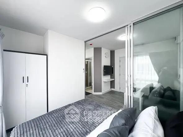 Modern bedroom with sleek design and sliding glass doors in a contemporary apartment.