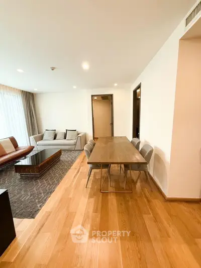 Spacious modern living room with dining area and elegant wooden flooring.