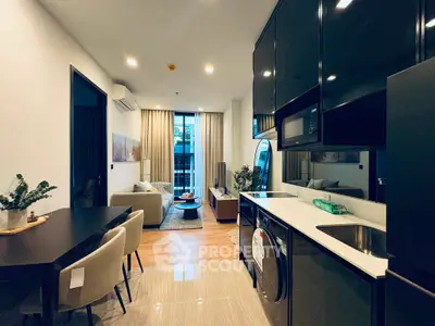 Modern open-plan living room and kitchen with sleek design and natural light.