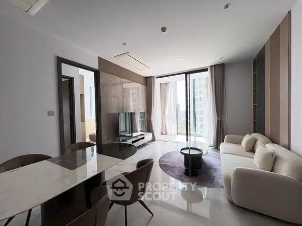 Luxurious modern living room with elegant furniture and large windows offering stunning city views.