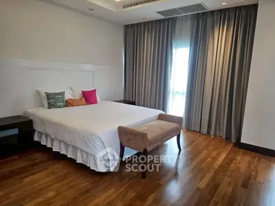 Spacious bedroom with elegant decor and hardwood flooring