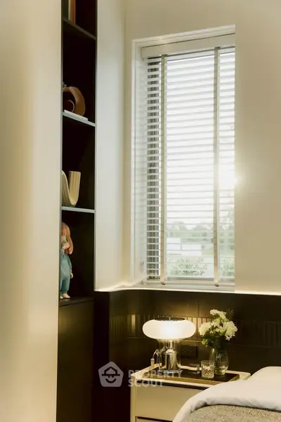 Cozy bedroom corner with modern decor and natural light through blinds.