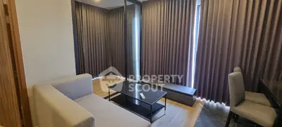 Modern living room with sleek furniture and floor-to-ceiling curtains, perfect for urban living.