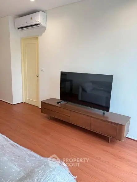 Modern living room with sleek TV setup and wooden flooring