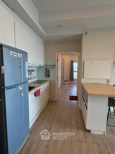 Modern kitchen with sleek appliances and open layout leading to a bright living area.