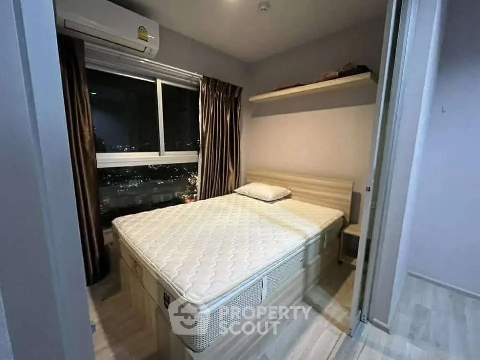 Cozy bedroom with city view, featuring a comfortable bed and modern air conditioning.