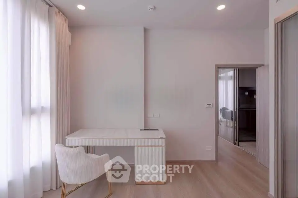 Elegant study room with modern desk and chair, featuring soft lighting and minimalist decor.