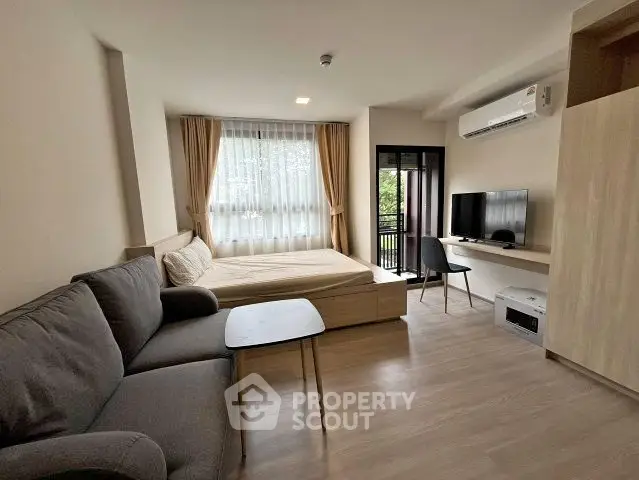 Modern studio apartment with cozy living area and balcony view