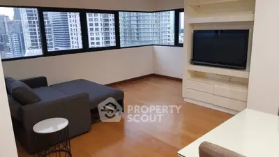 Spacious living room with city view and modern furnishings in high-rise apartment.