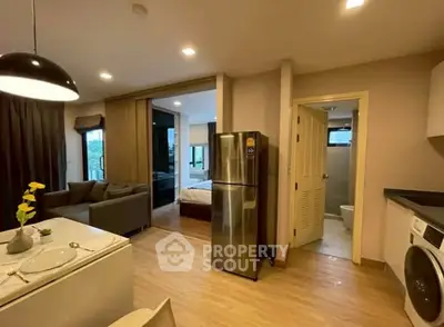 Modern open-plan apartment with kitchen, living area, and bedroom in view.
