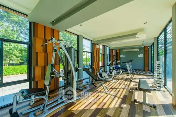 Spacious and modern gym with state-of-the-art equipment and large windows offering scenic views.