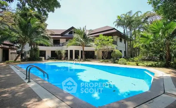 Luxurious villa with stunning pool and lush garden surroundings.