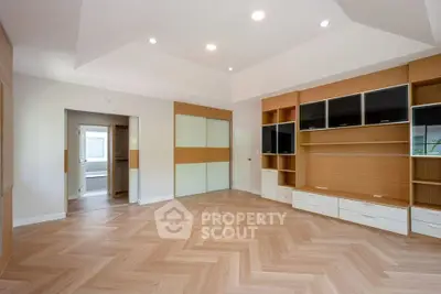 Spacious modern living room with built-in shelving and herringbone flooring