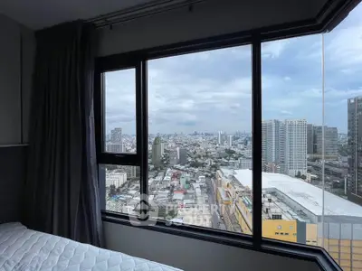 Stunning cityscape view from a high-rise bedroom window, showcasing urban skyline and modern architecture.