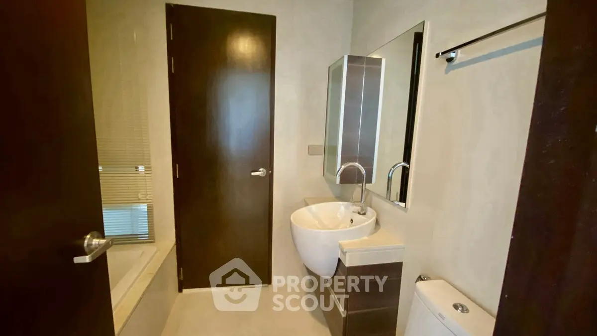 Modern bathroom with sleek fixtures and bathtub in a contemporary home.