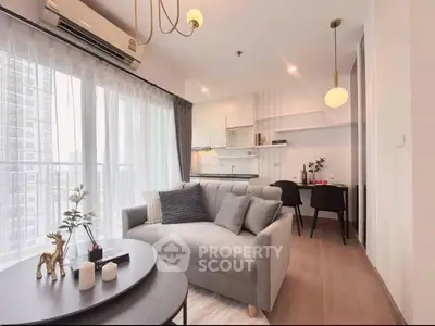 Modern living room with stylish decor and open kitchen layout in a high-rise apartment.