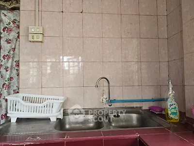 Charming kitchen with dual sink and floral curtain, perfect for cozy home cooking.