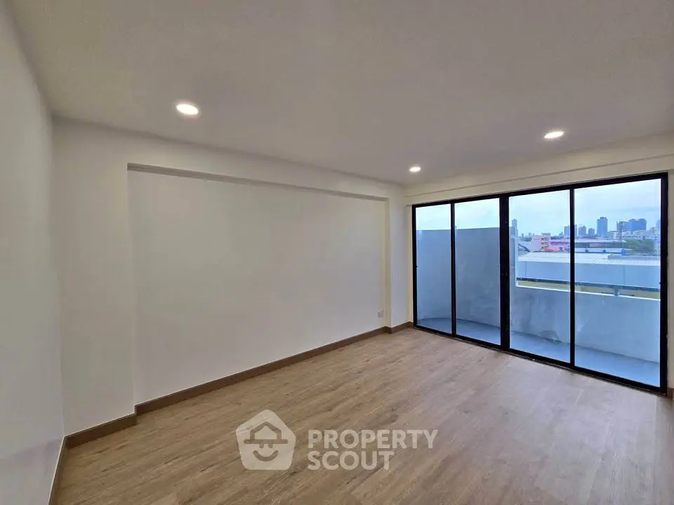 Spacious modern room with large windows and city view, perfect for urban living.