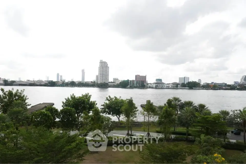 Stunning riverfront view with lush greenery and city skyline, perfect for serene living.