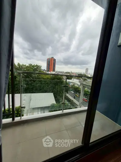 Stunning city view from a modern balcony with glass railing.