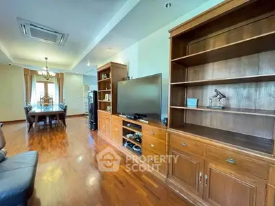 Spacious living room with elegant wooden furniture and dining area, perfect for family gatherings.