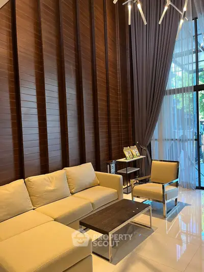 Elegant living room with modern furniture and floor-to-ceiling windows in a luxurious apartment.