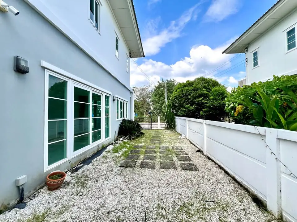 Charming exterior view of modern home with lush greenery and spacious walkway.