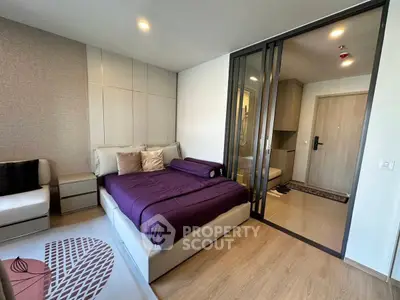 Modern bedroom with stylish decor and sliding glass doors in a contemporary apartment.