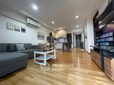 Spacious modern living room with open kitchen and wooden flooring