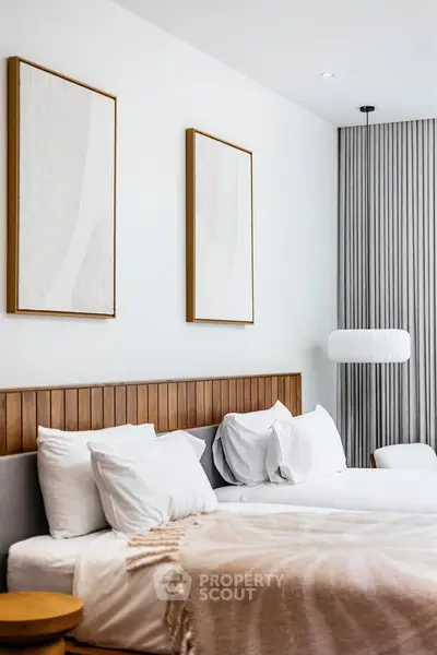 Modern bedroom with elegant decor and cozy ambiance, featuring stylish artwork and soft lighting.