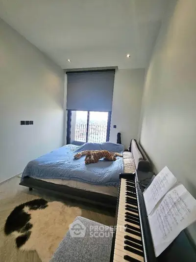 Modern bedroom with piano and plush tiger on bed, featuring large window and cozy decor.