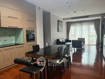 Spacious modern living room with open kitchen and elegant dining area, featuring hardwood floors and natural light.