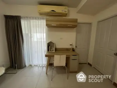 Modern study room with sleek desk and air conditioning in a cozy apartment.