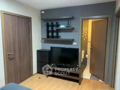 Modern living room with wooden flooring, TV unit, and open shelving for stylish urban living.