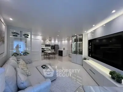 Luxurious modern living room with open kitchen, sleek design, and elegant lighting.