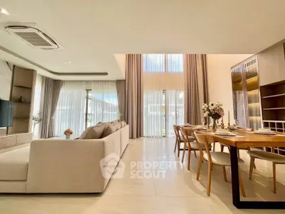 Luxurious open-plan living and dining area with high ceilings and elegant decor.