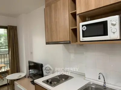 Modern kitchen with microwave and electric stove in cozy apartment