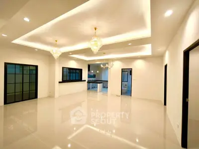 Spacious modern living room with elegant chandeliers and open kitchen layout