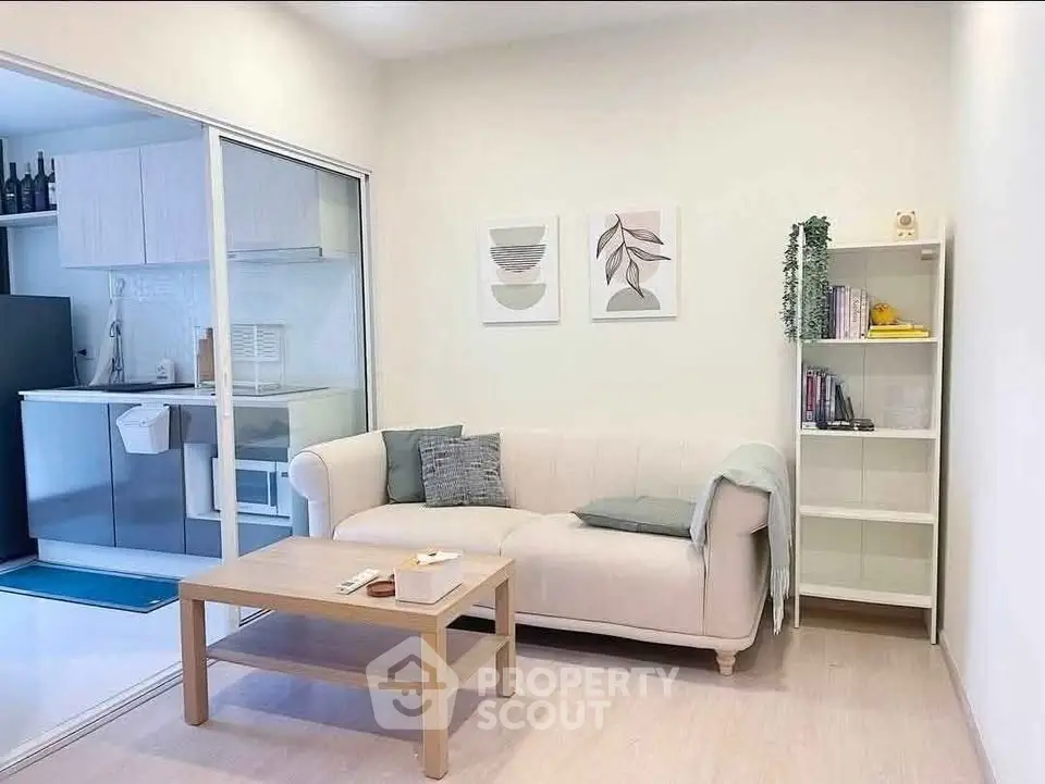 Modern living room with cozy sofa and open kitchen layout in stylish apartment.