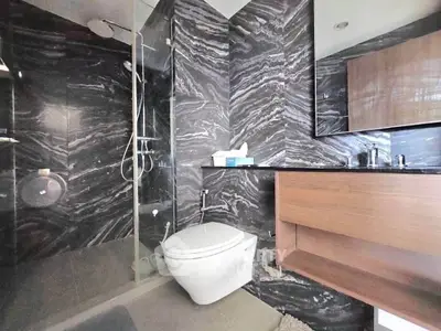 Luxurious modern bathroom with sleek black marble walls and glass shower enclosure
