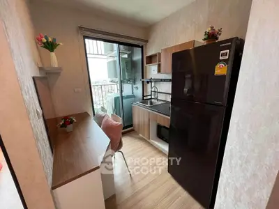 Modern kitchen with sleek black fridge and open balcony view