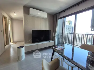 Modern living room with large TV and balcony view in high-rise apartment