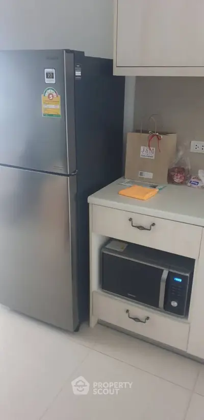 Modern kitchen corner with stainless steel fridge and microwave
