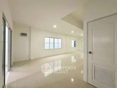 Spacious modern living room with glossy tiled floors and large windows for natural light.
