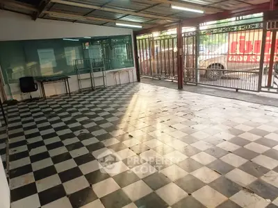 Spacious commercial space with checkered flooring and large windows for lease.
