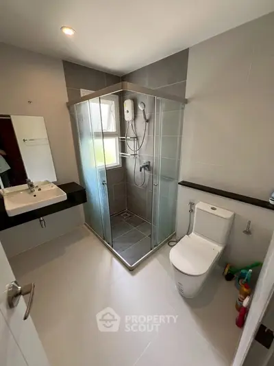Modern bathroom with glass shower enclosure and sleek fixtures