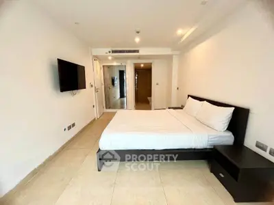 Spacious modern bedroom with minimalist design and wall-mounted TV