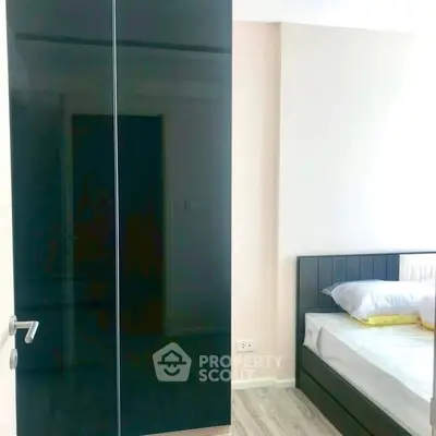 Modern bedroom with sleek black wardrobe and cozy bed setup