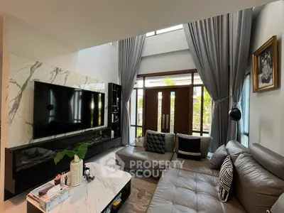 Luxurious living room with high ceilings, modern decor, and large windows for natural light.