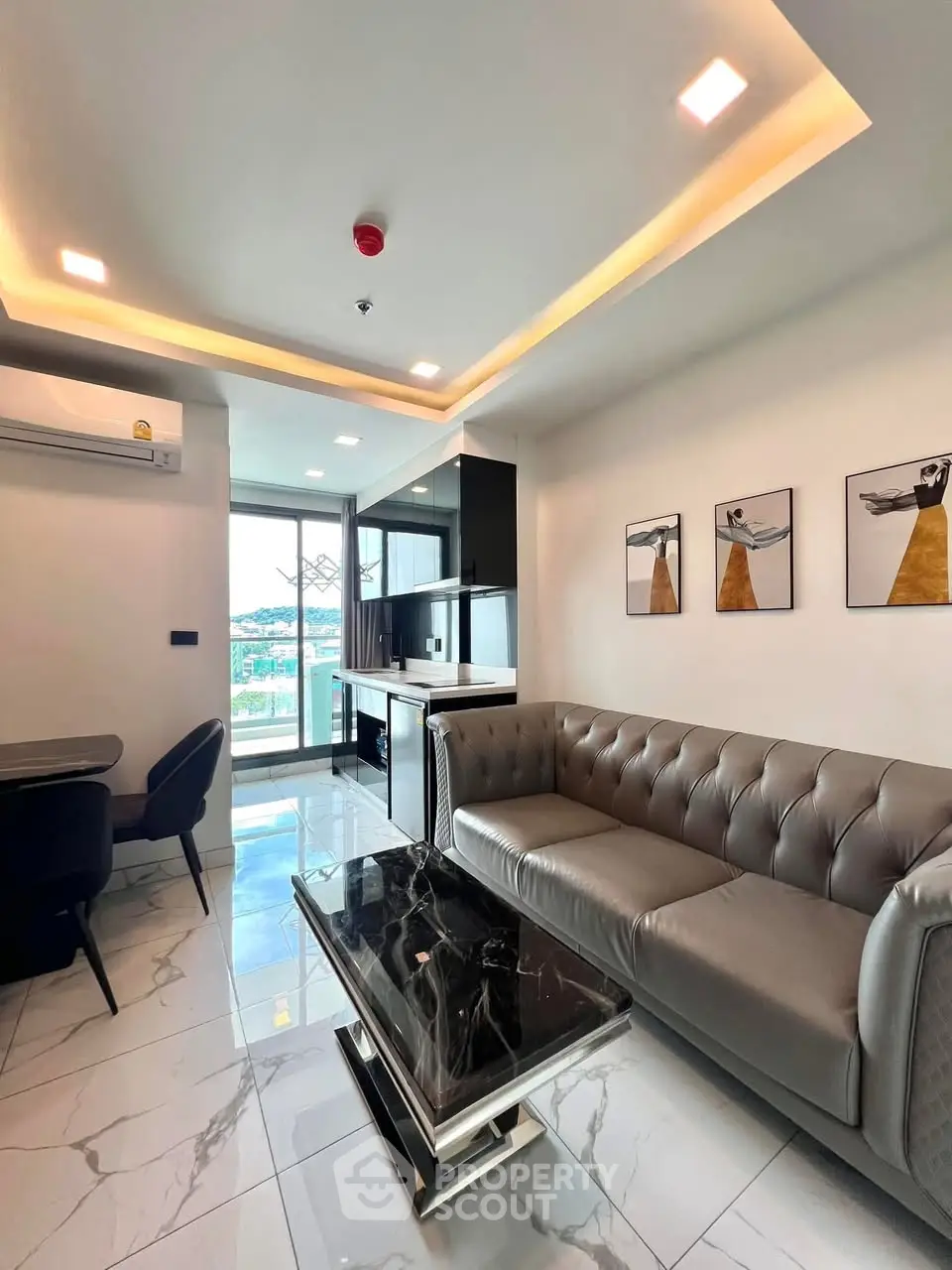 Modern living room with sleek design, marble table, and city view balcony.